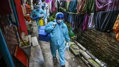 Petugas kesehatan tentara berjalan melalui gang saat melakukan vaksinasi virus corona COVID-19 untuk penduduk sebuah wilayah di Kolombo, Sri Lanka, Kamis (12/8/2021). (Ishara S. KODIKARA/AFP)