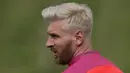 Memulai musim 2016/2017 bersama Barcelona, Lionel Messi tampil dengan gaya rambut berwarna pirang. Mewarnai rambut sepertinya menjadi tren bagi sejumlah bintang lapangan hijau, selain Messi ada juga Aaron Ramsey. (AFP/Oli Scarff)