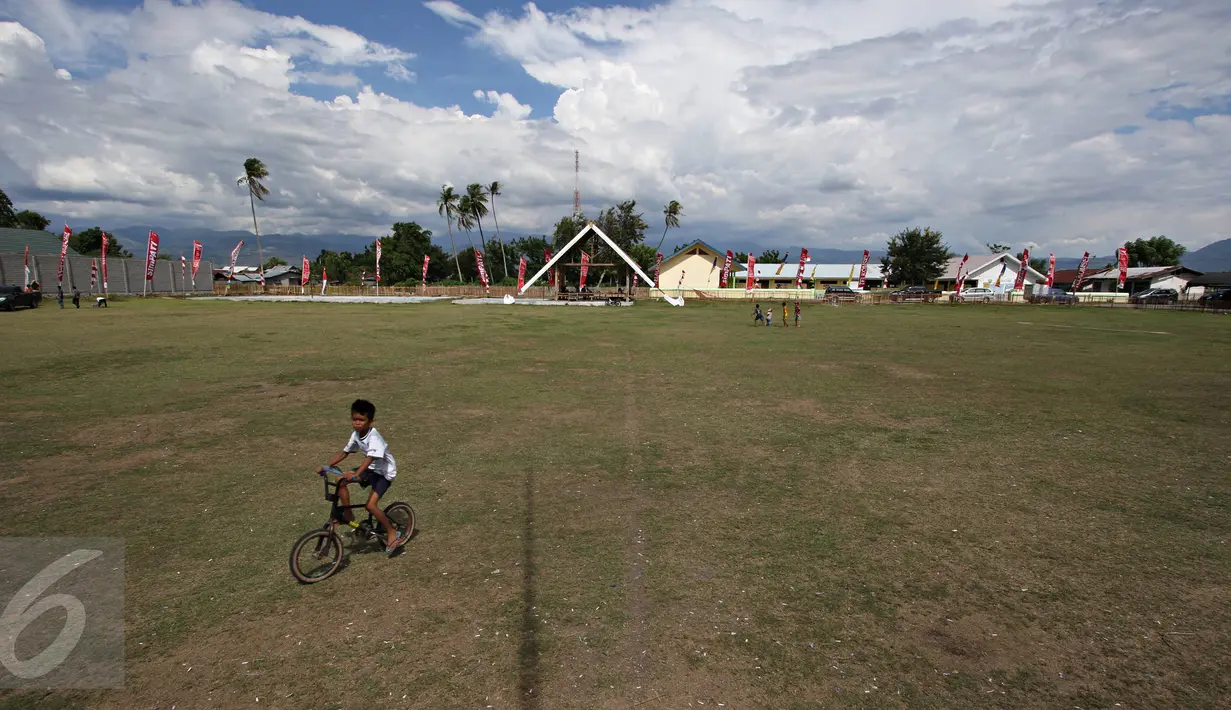 Seorang anak bermain sepeda di Lapangan Sepak Bola Kota Palu, Sigi, Sulteng, Selasa (8/3). Rencananya di lapangan tersebut, Wapres Jusuf Kalla dan istrinya, Mufida Kalla akan menyaksikan fenomena Gerhana Matahari Total. (Liputan6.com/Immanuel Antonius)