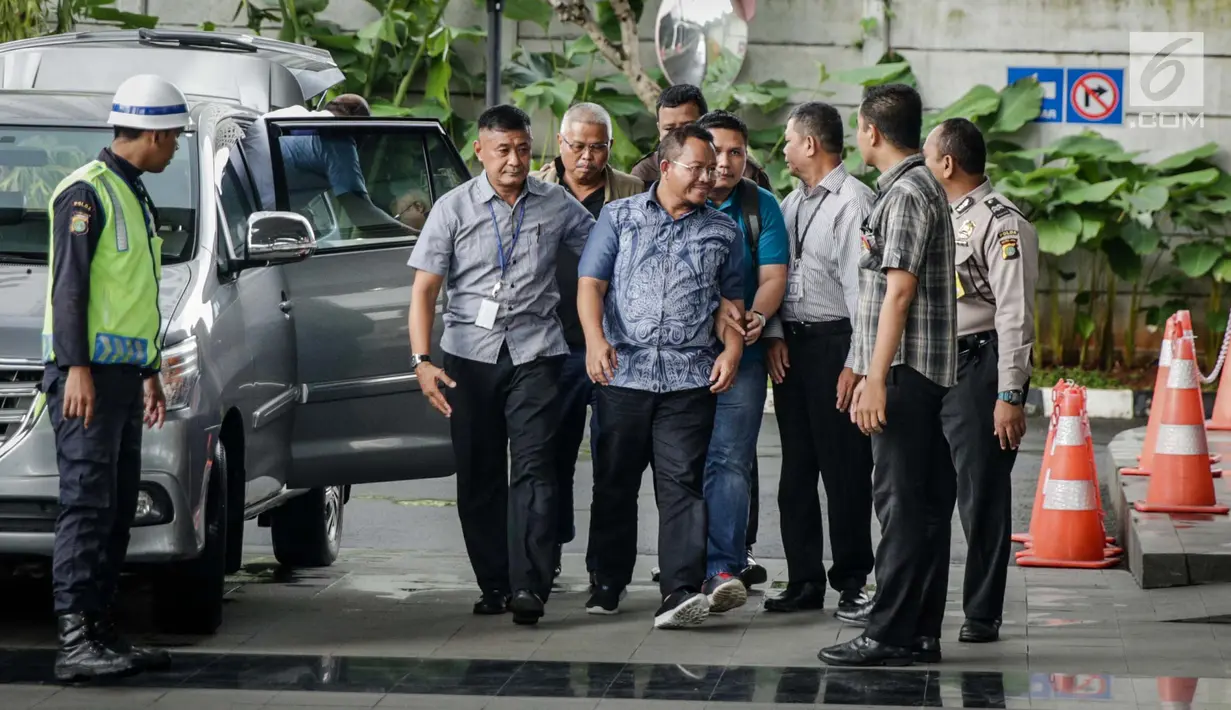 Anggota DPRD Provinsi Jambi Supriyono (depan), PLT Dinas PUPR Jambi Arfan (belakang) dikawal petugas memasuki Gedung KPK, Jakarta, Rabu (29/11). Ada uang lebih dari Rp 1 miliar diduga suap yang diamankan. (Liputan6.com/Faizal Fanani)