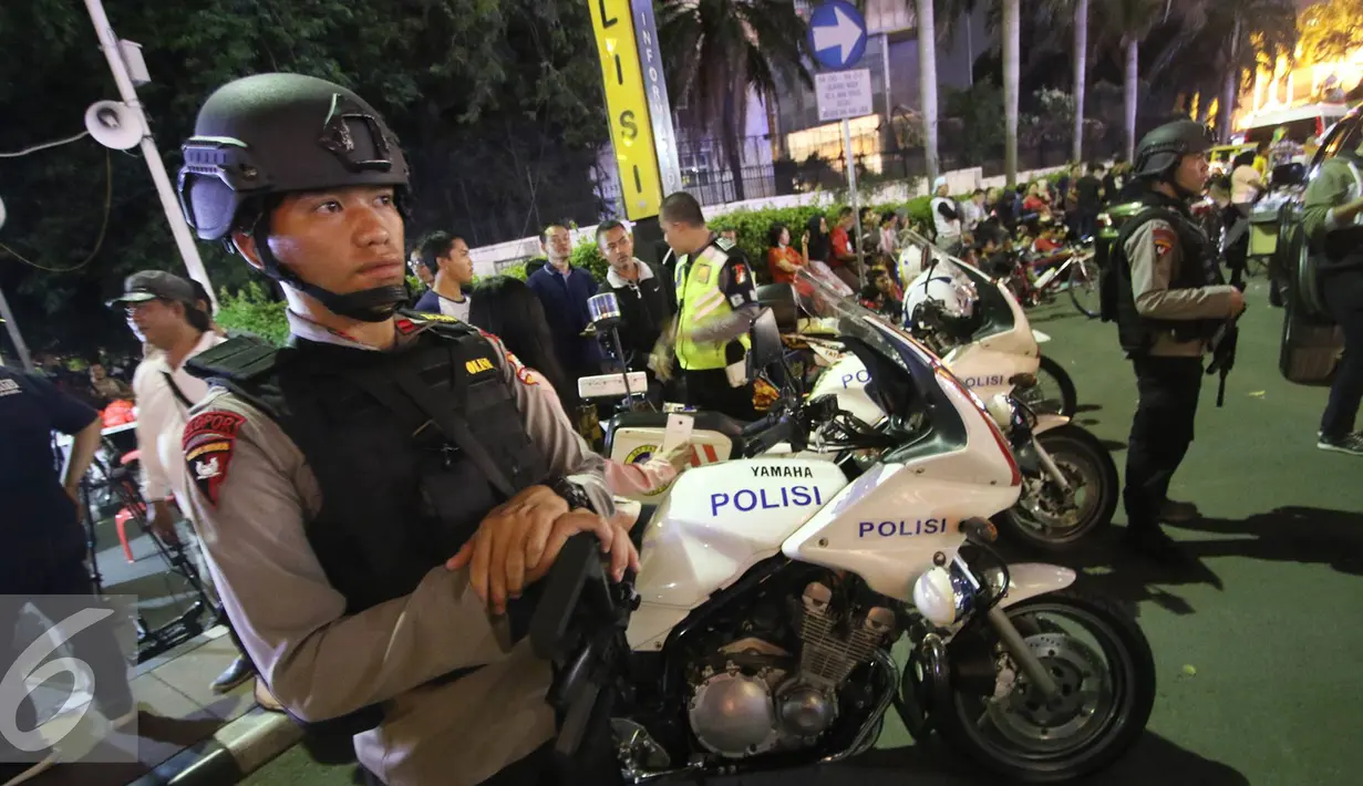 Petugas kepolisian bersenjata lengkap berjaga di kawasan Bundaran HI, Jakarta, Sabtu (31/12). Polisi berjaga di kawasan sekitar Bundaran Hotel Indonesia yang dipadati pengunjung menjelang pergantian tahun 2017. (Liputan6.com/Immanuel Antonius)