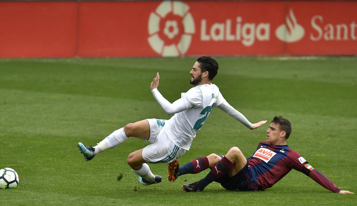 Gelandang Real Madrid, Isco, terjatuh saat berebut bola dengan gelandang Eibar, Dani Garcia, pada laga La Liga di Stadion Ipurua, Sabtu (10/3/2018). Eibar takluk 1-2 dari Real Madrid. (AP/Alvaro Barrientos)