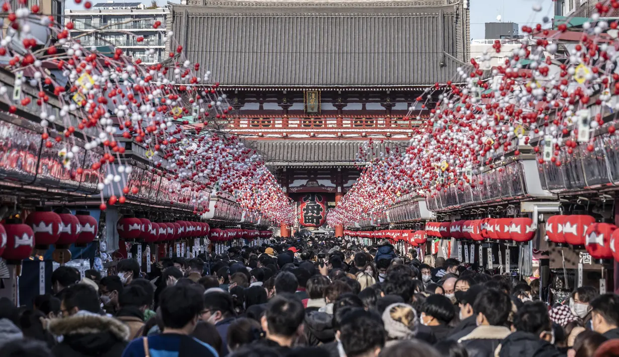 Orang-orang mengunjungi kuil Sensoji menjelang liburan Tahun Baru di Tokyo pada 30 Desember 2022. Pada malam tahun baru, joya no kane atau lonceng malam tahun baru akan berdentang nyaring dari kuil ini. Lonceng tersebut menandakan bahwa pada saat itu hari dan tahun telah berganti menjadi 1 Januari. (AFP/Yuichi Yamazaki)