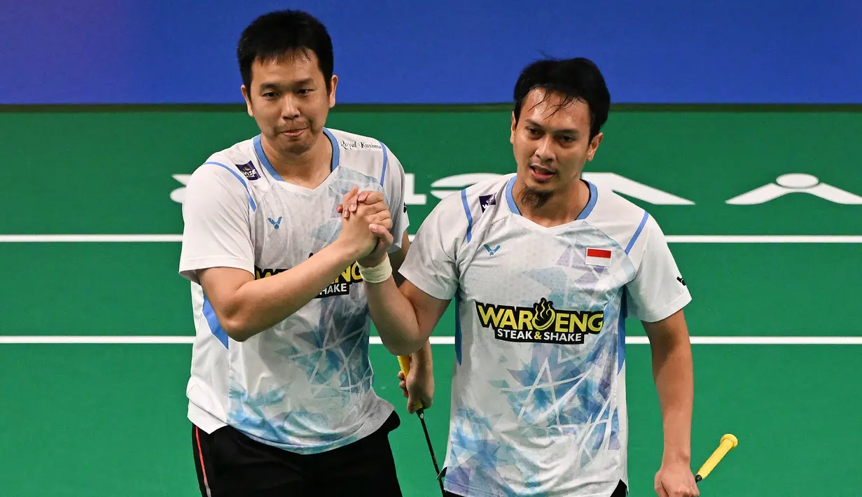 Pebulutangkis ganda putra Indonesia, Mohammad Ahsan (kanan) dan Hendra Setiawan merayakan kemenangan mereka atas wakil Australia, Pramudya Kusumawardan/Andika Ramadiansyah dalam pertandingan perempat final Australia Open di Quaycentre, Sydney, 14 Juni 2024. (Saeed KHAN/AFP)
