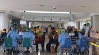 Pekerja migran menjalani tes Covid-19 di Bandara Juanda. (Dian Kurniawan/Liputan6.com)
