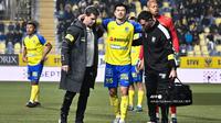 Bek STVV asal Jepang, Shogo Taniguchi (tengah), berjalan dan dibantu keluar lapangan selama pertandingan sepak bola Divisi Pertama "Liga Pro" Belgia antara Sint-Truidense VV dan KV Mechelen di Stadion Stayen di Sint-Truiden, Sabtu dini hari WIB (9/11/2024). (Johan Eyckens/BELGA/AFP)