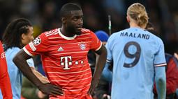 Reaksi pemain Bayern Munchen, Dayot Upamecano setelah timnya dikalahkan Manchester City dengan skor 0-3 pada laga leg pertama perempat final Liga Champions 2022/2023 di Etihad Stadium, Manchester, Rabu (12/04/2023) WIB. Upamecano menjadi titik terlemah di pertahanan Die Roten. Ia benar-benar kesulitan berduel satu lawan satu dengan Haaland dan membuat blunder fatal pada gol Bernardo Silva. (AFP/Paul Ellis)