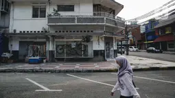 Warga berjalan di dekat pertokoan yang tutup di kawasan little Tokyo, Blok M, Jakarta, Rabu (21/7/2021). Pemerintah resmi menetapkan pemberlakuan pembatasan kegiatan masyarakat (PPKM) level 4 hingga 25 Juli mendatang untuk mencegah penyebaran virus Covid-19. (Liputan6.comn/Faizal Fanani)