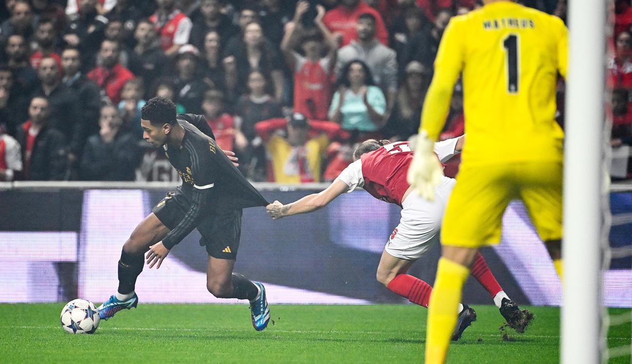 Pamain Real Madrid, Jude Bellingham, berusaha melepaskan diri dari penjagaan ketat pemain Braga, Serdar Saatci, pada matchday 3 Liga Champions 2023/2024 di Stadion Municipal, Rabu (25/10/2023). Madird menang dengan skor 2-1. (AFP/Miguel Riopa)