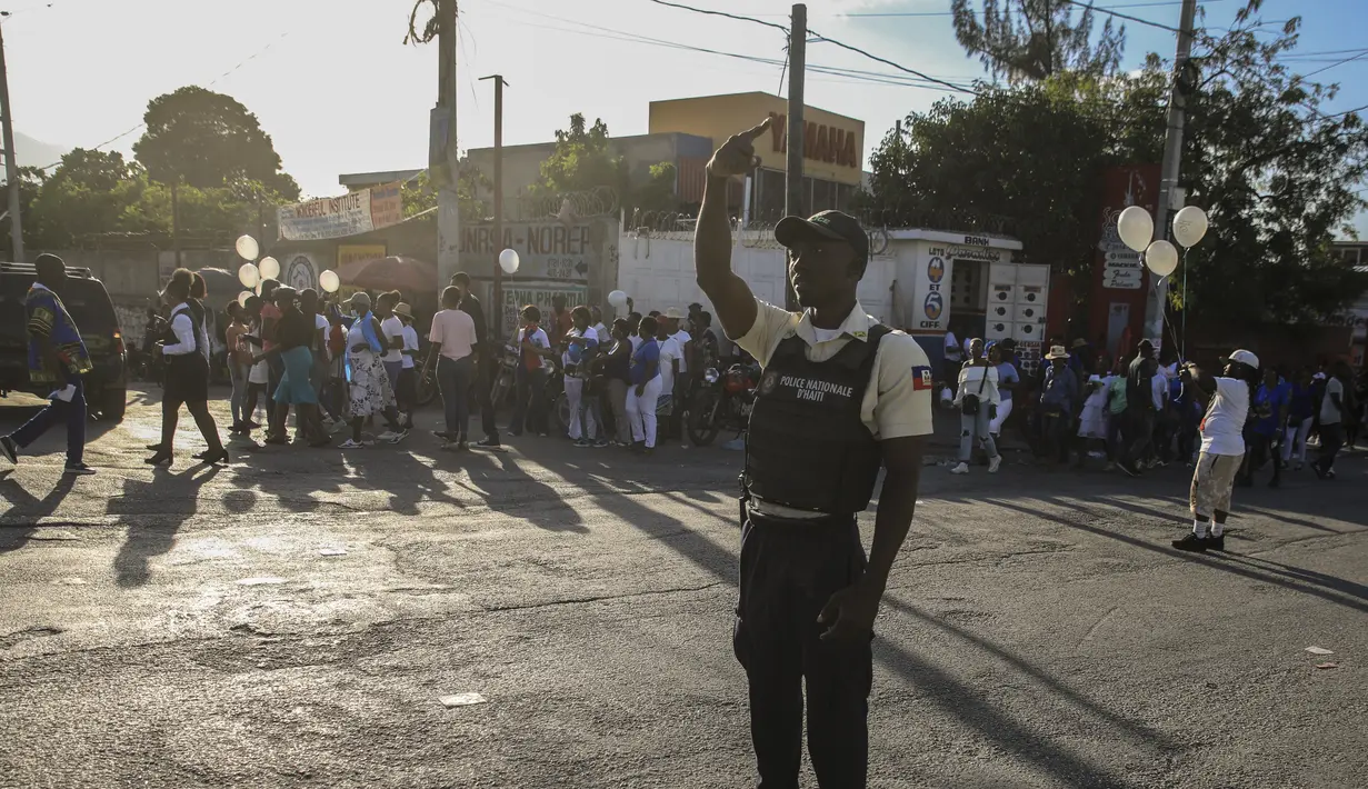 Seorang anggota polisi nasional mengontrol keamanan di sebuah jalan di Port-au-Prince, Haiti, Sabtu (21/1/2023). Geng yang kuat dan bersenjata lengkap menguasai sebagian besar negara dan kerap kali menculik orang dan menahan mereka untuk tebusan. (AP Photo/Megan Janetsky)