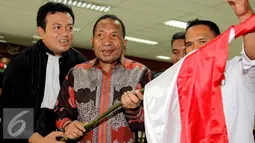 Jelang sidang perdana,  Jannes Johan Karubaba membawa Bendera merah putih, Jakarta, Senin (13/7/2015). Karubaba diduga melakukan korupsi pengadaan "Detailing Engineering Design" di Sungai Mamberamo dan Urumka. (Liputan6.com/Helmi Afandi)