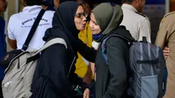 Seorang mahasiswa (kanan) yang dipulangkan dari karantina virus corona atau COVID-19 di Natuna memeluk keluarganya saat tiba di Bandara Internasional Sultan Iskandar Muda, Blang Bintang, Aceh, Senin (17/2/2020). Kepulangan mahasiswa Aceh ini disambut suka cita keluarga. (CHAIDEER MAHYUDDIN/AFP)