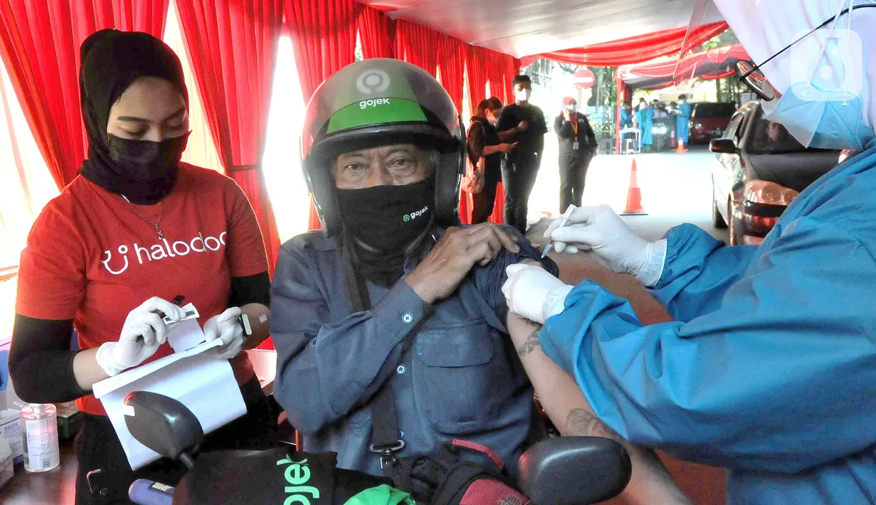 Paramedis menyuntikkan vaksin COVID-19 secara drive thru kepada pengendara sepeda motor di GOR Pajajaran, Kota Bogor, Jawa Barat, Rabu (17/3/2021). Kegiatan ini menargetkan 600 warga per hari dan berlangsung hingga tiga bulan ke depan. (merdeka.com/Arie Basuki)