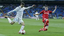 Pemain Real Madrid, Achraf Hakimi (kiri) mencoba melepaskan tembakan melewati pemain Numancia, Nacho Sanchez pada laga Copa Del Rey di Santiago Bernabeu stadium, Madrid, (10/01/2018). Real Madrid unggul agregat 5-2 atas Numancia. (AP/Francisco Seco)