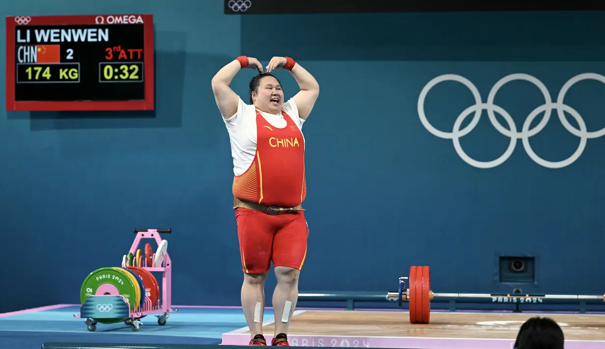 Lifter China, Li Wenwen melakukan selebrasi dengan membuat gestur hati setelah memastikan dirinya meraih medali emas cabang olahraga angkat besi +81kg putri Olimpiade Paris 2024 di South Paris Arena, Paris, Prancis, Sabtu (11/08/2024). (AFP/Arun Sankar)