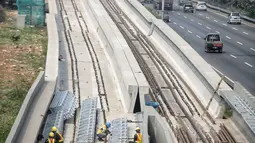 Pekerja menyelesaikan pembangunan proyek kereta api ringan (light rail transit/LRT) di kawasan Kampung Makasar, Jakarta, Kamis (26/7). Secara keseluruhan, proyek kereta ringan atau LRT Jakarta telah rampung sekitar 85 persen. (Liputan6.com/Faizal Fanani)