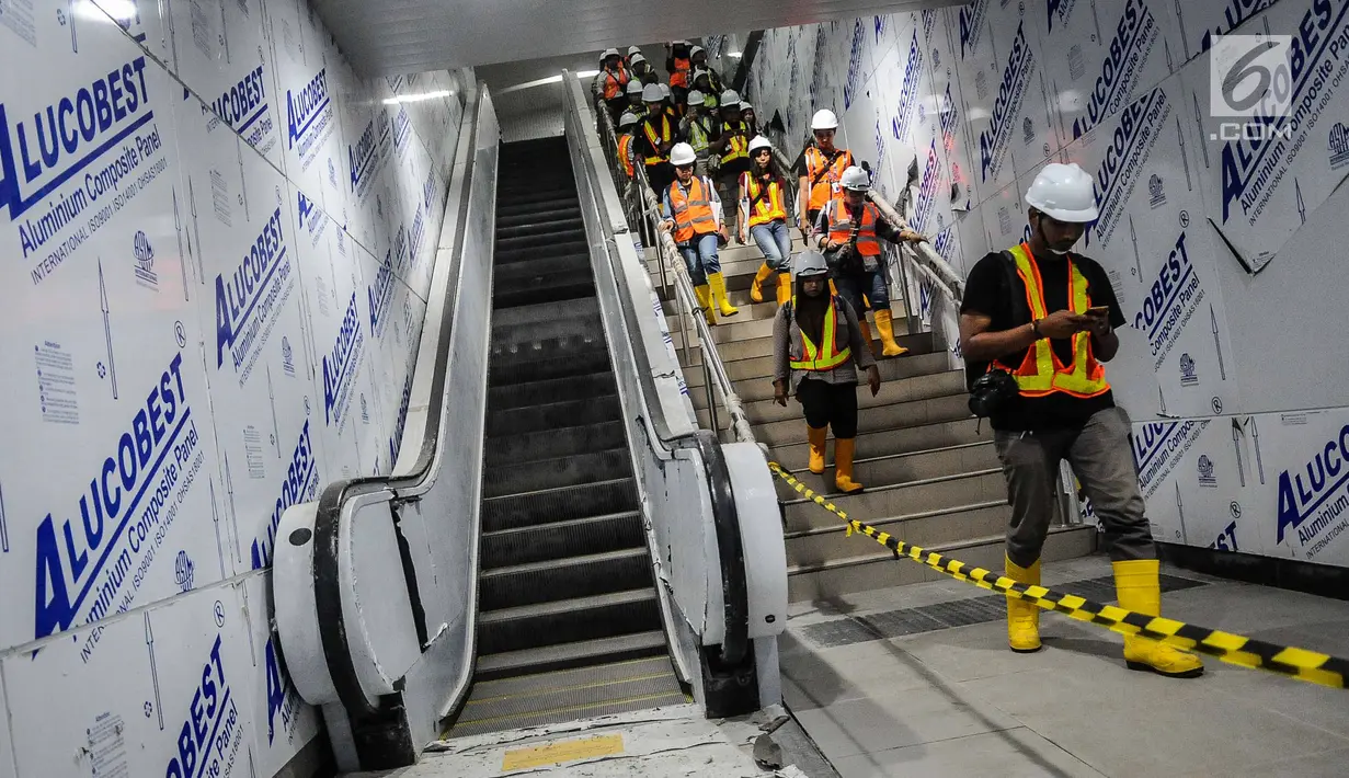 Wartawan menuruni tangga di Stasiun Mass Rapid Transit (MRT) Bundaran HI, Jakarta, Senin (10/12). (Liputan6.com/Faizal Fanani)