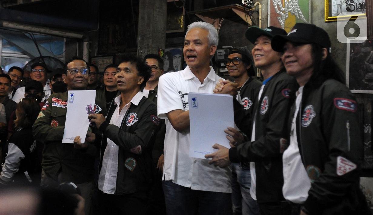 Calon presiden dan calon wakil presiden nomor urut tiga Ganjar Pranowo dan Mahfud MD foto bersama grup band Slank saat berkunjung ke Markas Slank di Jalan Potlot, Jakarta, Sabtu (20/1/2024). Slank mendeklarasikan dukungannya kepada pasangan Ganjar Pranowo - Mahfud MD pada Pilpres 2024. (merdeka.com/Imam Buhori)