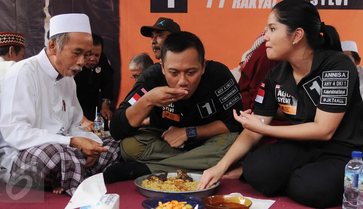 Calon Gubernur DKI Jakarta Agus Harimurti Yudhoyono bersama istrinya, Annisa Pohan menikmati nasi kebuli di Kampung Bidaracina, Jakarta, Rabu (30/1). Agus menggelar kampanye tatap muka dengan para warga di wilayah tersebut. (Liputan6.com/Gempur M Surya)