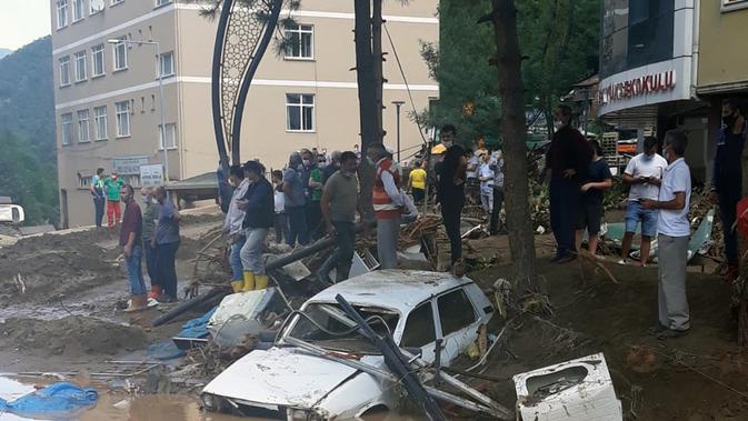 Orang-orang berkumpul di area yang terdampak banjir di Provinsi Giresun, kawasan Laut Hitam, Turki (23/8/2020). Banjir yang melanda Giresun pada Minggu (23/8) menewaskan enam orang, termasuk dua personel Gendarmerie, demikian dilaporkan kantor berita semiresmi Turki Anadolu Agency. (Xinhua)