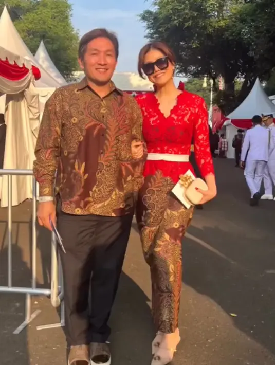 Agatha Suci tampil dengan kebaya merah brokat dengan inner bra top hitam. Dilakukan belt putih dan kain batik lilit sebagai bawahannya. [@agatha_suci]