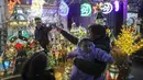 Warga Palestina berbelanja lentera tradisional "fanous" di Hebron di Tepi Barat yang diduduki pada 27 Maret 2022. Fanous merupakan lentera untuk dekorasi yang digunakan merayakan awal bulan suci Ramadan. (HAZEM BADER / AFP)