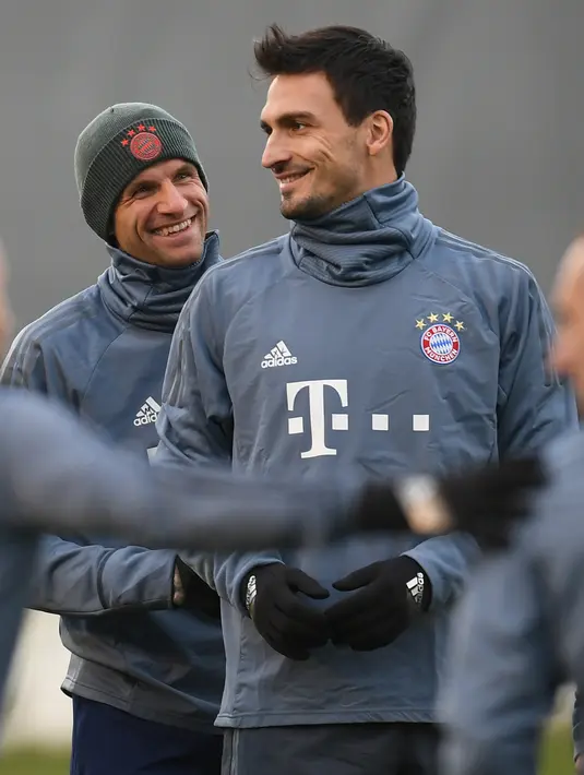 Bek Bayern Munchen, Mats Hummels dan striker Thomas Mueller tersenyum saat latihan di Munich, Jerman selatan (12/3). Bayern Munchen akan bertanding melawan wakil Inggris, Liverpool pada leg kedua babak 16 besar Liga Champions. (AFP Photo/Christof Stache)
