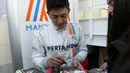 Pebalap F1 asal Indonesia, Rio Haryanto, dengan penuh keramahan memberikan tanda tangan kepada fans usai jumpa pers di Sirkuit Catalunya, Spanyol. Pebalap asal tim Manor ini memang dikenal sebagai sosok yang ramah. (AFP/Josep Lago)