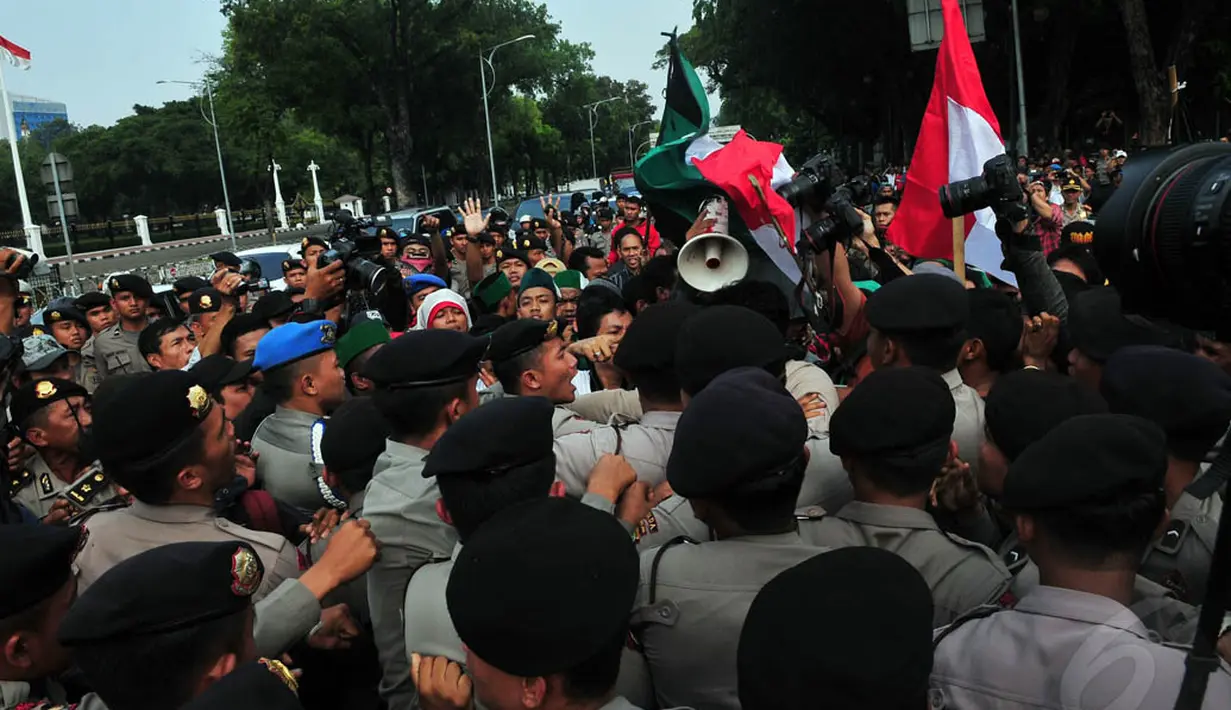 Mahasiswa sempat terlibat aksi saling dorong dengan aparat kepolisian di depan Istana Negara, Jakarta, Rabu (19/11/2014). (Liputan6.com/Johan Tallo) 