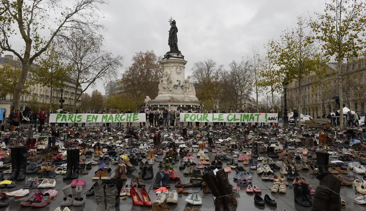 Ribuan pasang sepatu yang dikirimkan aktivis dipajang di place de la Republique, Prancis, sebagai tanda solidaritas karena pawai lingkungan di Paris dibatalkan jelang Konferensi Tingkat Tinggi Perubahan Iklim, Minggu (29/11).  (AFP PHOTO/Miguel Medina)