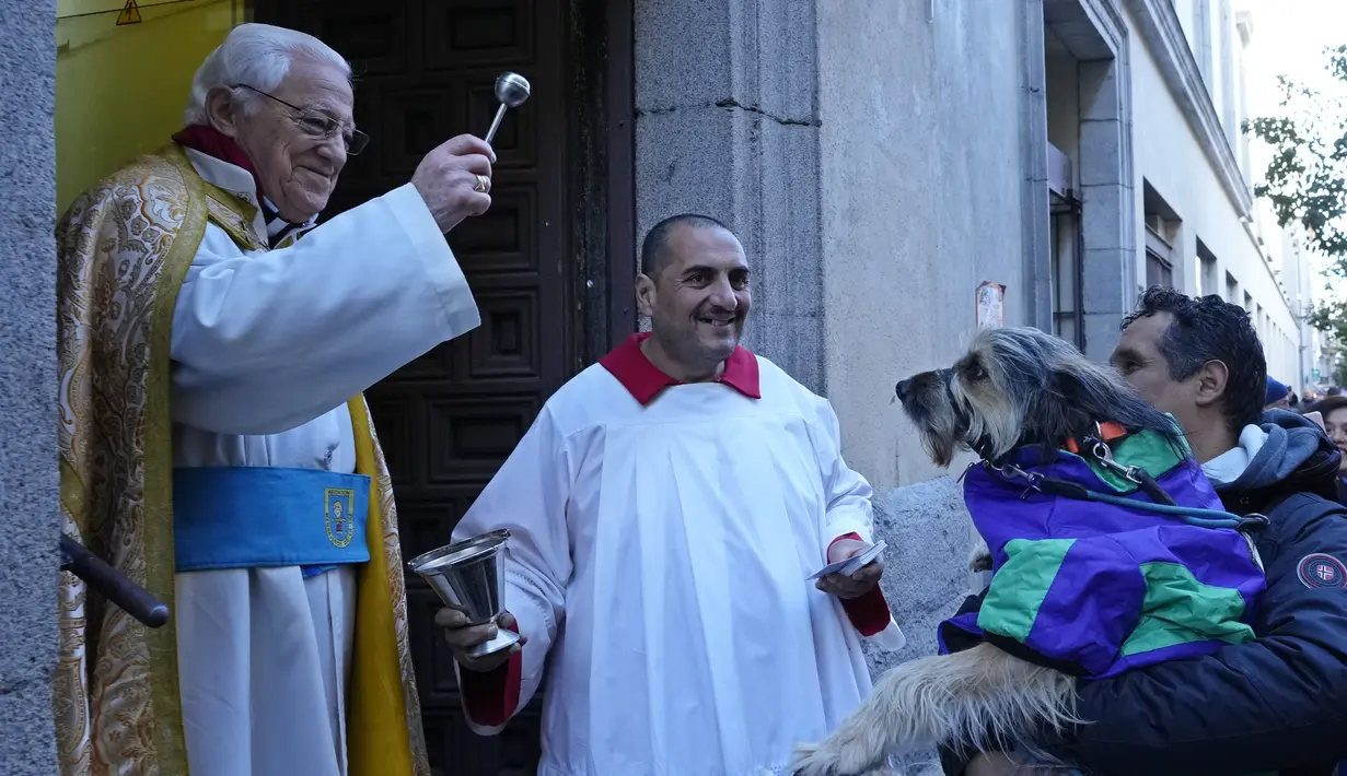 Pastor Angel memercikkan air suci pada seekor anjing di gereja San Anton selama pesta Santo Antonius, santo pelindung hewan, di Madrid, Spanyol, Selasa (17/1/2023). Pesta itu dirayakan setiap tahun di banyak bagian Spanyol dan orang-orang membawa hewan mereka ke gereja untuk diberkati. (AP Photo/Paul White)