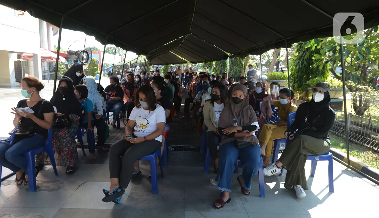 Warga menunggu untuk mengikuti vaksinasi COVID-19 di Plaza Pondok Gede, Bekasi, Jawa Barat, Selasa (27/7/2021). Vaksinasi dilakukan kepada warga usia minimal 12 tahun guna menekan penyebaran COVID-19. (merdeka.com/Imam Buhori)