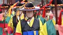 Anggota penjaga istana dengan mengenakan masker ambil bagian dalam upacara pergantian penjaga bagi wisatawan di gerbang utama Istana Deoksugung di Seoul, Rabu (18/11/2020). Upacara Pergantian Penjaga Kerajaan diadakan mulai hari Selasa hingga Minggu, sebanyak tiga kali sehari. (Jung Yeon-je AFP)