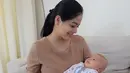 Titi memang tidak berlebihan saat berpenampilan. Namun, ia selalu berhasil memancarkan aura keibuannya yang cantik jelita. Seperti ini misalnya, penampilan Titi begitu sederhana saat menggendong baby Kai Attar Sugiono. (Instagram/titi_kamall)