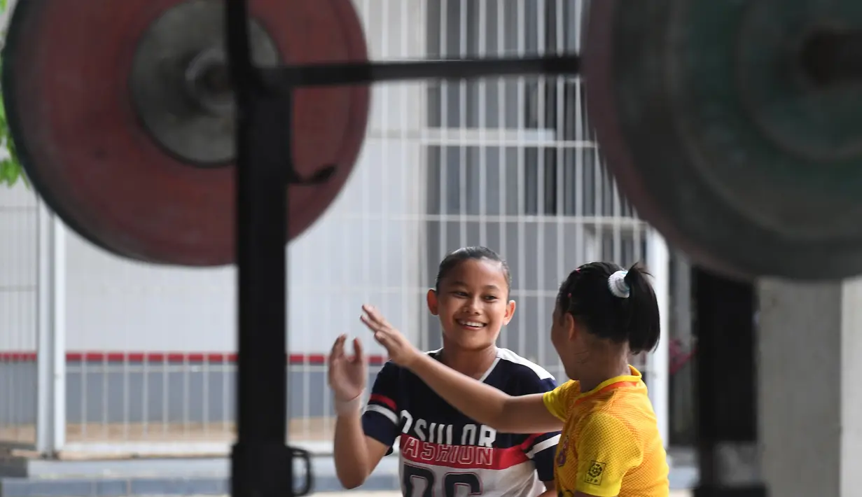 Sejumlah anak tengah berbincang saat pelatihan angkat besi di Padepokan Gajah, sebuah akademi swasta di Pringsewu, Kabupaten Lampung, Sumatera Selatan (7/11). (AFP Photo/GOH Chai Hin)