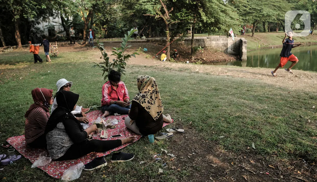 Warga saat bersantai di pinggir Waduk Setu, Cipayung, Jakarta, Selasa (28/7/2020). Pemerintah Kota (Pemkot) Jakarta Timur akan menjadikan Waduk Setu sebagai pusat ekowisata yang ditargetkan terwujud pada Oktober mendatang. (merdeka.com/Iqbal S. Nugroho)