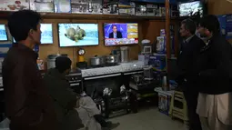 Warga Afghanistan melihat siaran langsung pemilihan presiden AS di sebuah kios perlengkapan memasak di Afghanistan Rabu (9/11). (AP Photo / Rahmat Gul)
