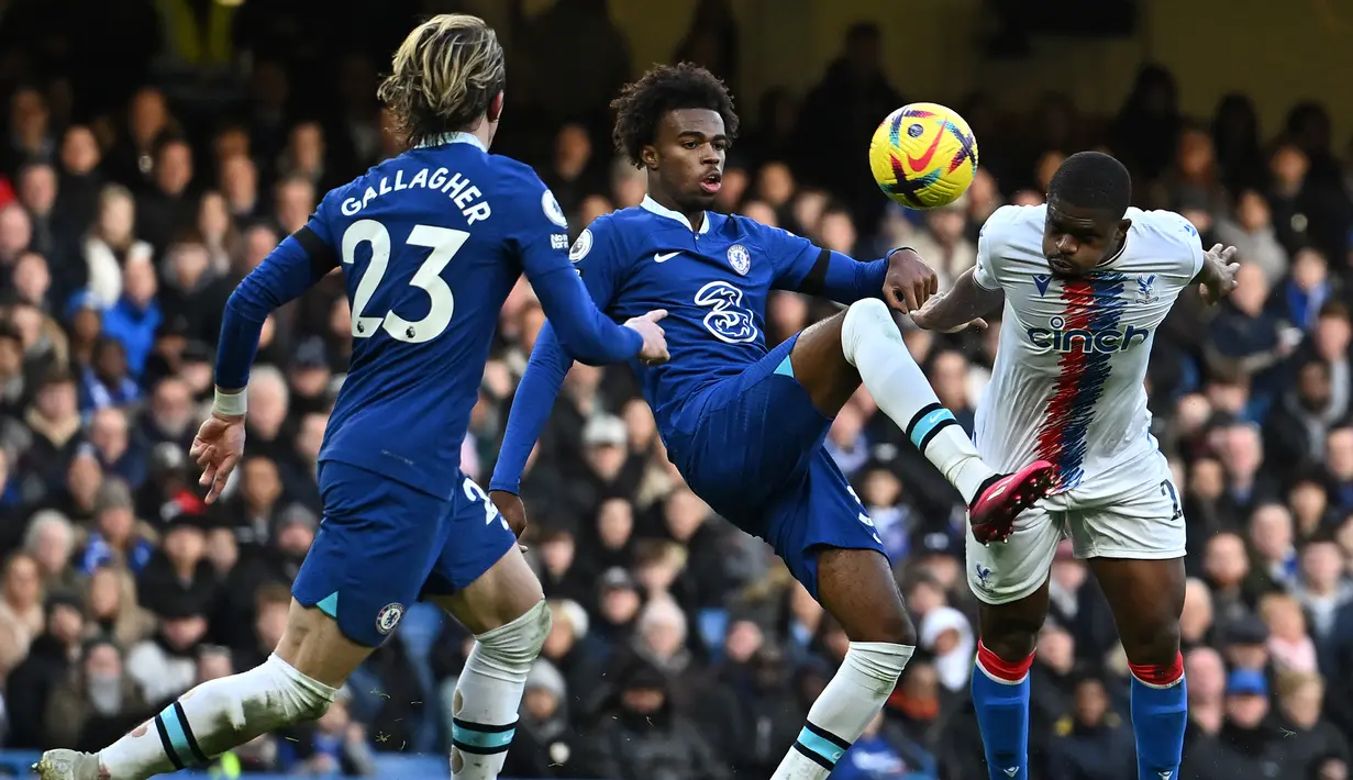 Gelandang Chelsea, Carney Chukwuemeka (tengah) berebut bola dengan gelandang Crystal Palace, Cheick Doucoure pada laga Liga Inggris 2022/2023 di Stamford Bridge, London (15/1/2023). Carney Chukwuemeka telah bermain bersama Aston Villa di Premier League sejak awal musim 2021/2022 saat dipromosikan dari tim Aston Villa U-23. Musim ini ia telah membela The Villans dalam 10 laga di Premier League. Bersama Timnas Inggris U-20 ia telah mengoleksi 3 caps sejak melakukan debut pada 21 September 2022. (AFP/Ben Stansall)