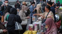Para penjual makanan (kanan) menyiapkan pesanan pelanggan di salah satu warung makan saat jam sibuk di Jakarta pada Kamis 21 Mei 2026. (BAY ISMOYO/AFP)