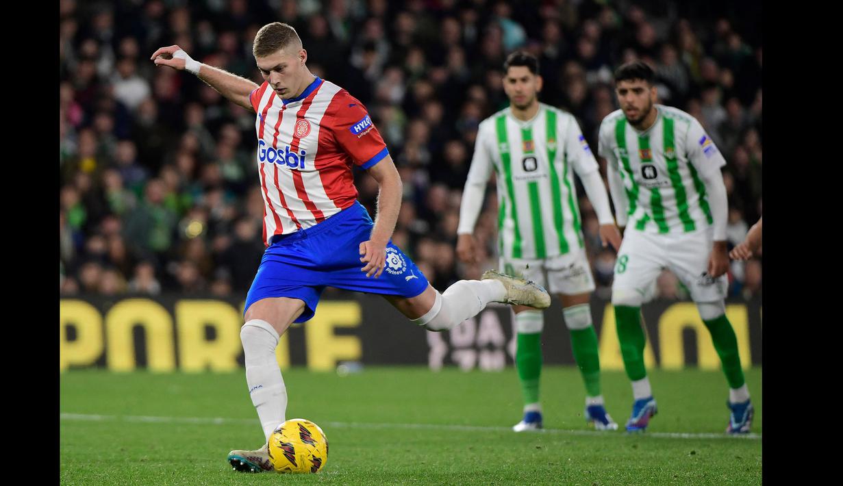 Pemain Girona, Artem Dovbyk mencetak gol melalui tendangan penalti ke gawang Real Betis pada laga pekan ke-18 Liga Spanyol 2023/2024 di Benito Villamarin Stadium, Sevilla, Spanyol, Jumat (22/12/2023) dini hari WIB. (AFP/Cristina Quicler)