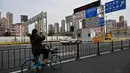 Seorang wanita mengambil gambar salah satu akses yang terkunci ke terowongan ke arah distrik Pudong yang dikunci sebagai tindakan melawan virus corona Covid-19, di Shanghai (28/3/2022). (AFP/Hector Retamal)