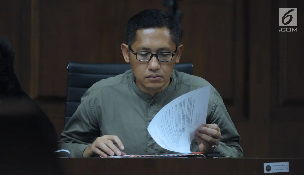 Anas Urbaningrum membaca berkas jelang mengikuti sidang lanjutan pengajuan PK kasus korupsi dan pencucian uang proyek P3SON Hambalang di Pengadilan Tipikor, Jakarta, Jumat (8/6). Sidang mendengar keterangan saksi. (Liputan6.com/Helmi Fithriansyah)