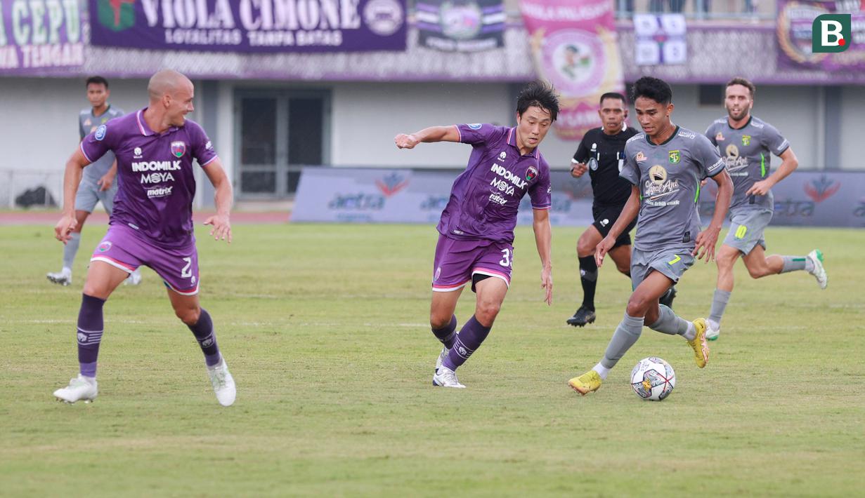 <p>Pemain Persebaya Surabaya, Marselino Ferdinan (kanan) berusaha melewati pemain Persita Tangerang, Shin Young-bae pada laga pekan ke-18 BRI Liga 1 2022/2023 di Stadion Indomilk Arena, Tangerang, Rabu (18/1/2023) sore WIB. Persebaya menang dengan skor 5-0. (Bola.com/M Iqbal Ichsan)</p>