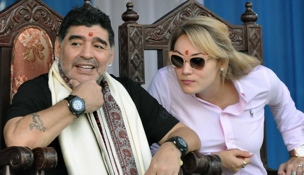 Legenda sepak bola Argentina Diego Maradona bersama istrinya  saat berkunjung di Kolkata, India (11/12). Maradona melakukan kunjungan pribadi ke India bersama sang istri. (AFP Photo)