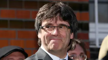 Mantan pemimpin Catalan, Carles Puigdemont tersenyum sebelum memberi keterangan kepada awak media setelah dibebaskan dengan jaminan dari penjara di Neumuenster, Jerman utara, (6/4). (Carsten Rehder / dpa via AP)