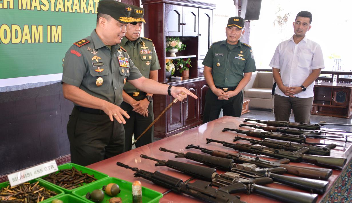 Panglima Kodam Iskandar Muda Mayjen TNI Teguh Arief Indratmoko memeriksa senjata bekas konflik di Banda Aceh, Aceh, Rabu (15/5/2019). Sembilan senjata laras panjang, tiga pistol, delapan granat, dan 455 butir amunisi tersebut diserahkan secara sukarela oleh warga. (CHAIDEER MAHYUDDIN/AFP)