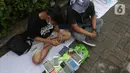 Penjual jasa perbaikan telepon genggam memperbaiki HP di trotoar jalan Mayjen Sutoyo depan Mall Pusat Grosir Cililitan (PGC), Jakarta, Rabu (14/7/2021). Kios yang biasa mereka tempati tutup seiring penutupan Mall PGC selama pemberlakuan PPKM Darurat Jawa-Bali. (Liputan6.com/Helmi Fithriansyah)