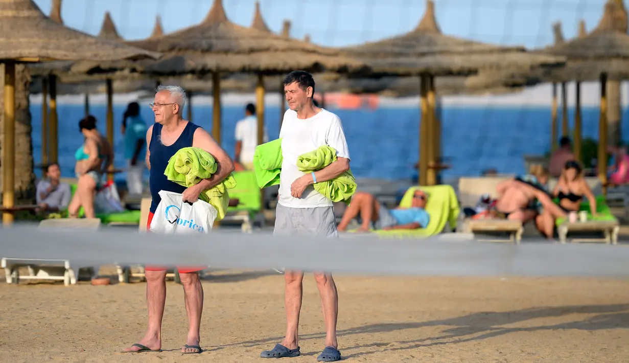Dua orang turis berjalan di pantai kota wisata Laut Merah Mesir, Hurghada pada 3 April 2019. Sepanjang tahun Hurghada beriklim tropis, sehingga banyak turis yang datang untuk merasakan musim panas dari bulan Januari sampai Desember. (Mohamed el-Shahed / AFP)
