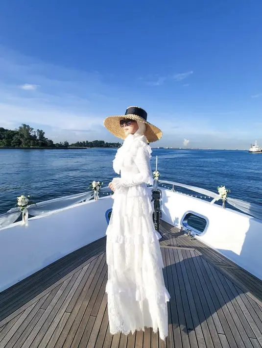 Dress tersebut pun dipadukan dengan berbagai aksesori penunjang penampilannya, seperti Syarini mengenakan boater hat lebar berpita hitam di atas kerudung putihnya, dipadukan kacamata hitam besar. @princessyahrini
