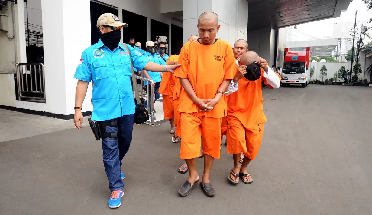 Petugas BNN menggiring tersangka penyelundup 44 bungkus narkotika jenis sabu usai rilis di Jakarta, Kamis (20/7). BNN menyita 44 bungkus sabu seberat 45,59 kg dari delapan orang tersangka. (Liputan6.com/Helmi Fithriansyah)